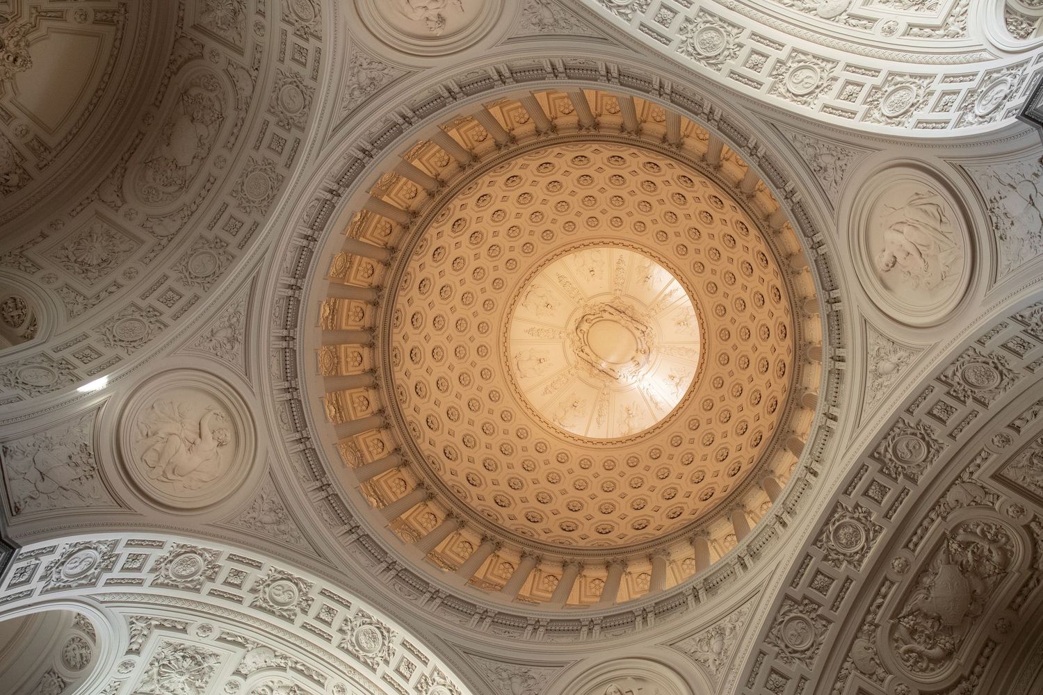 Ornate rotunda ceiling with intricate coffered dome, decorative medallions, and golden architectural details.
