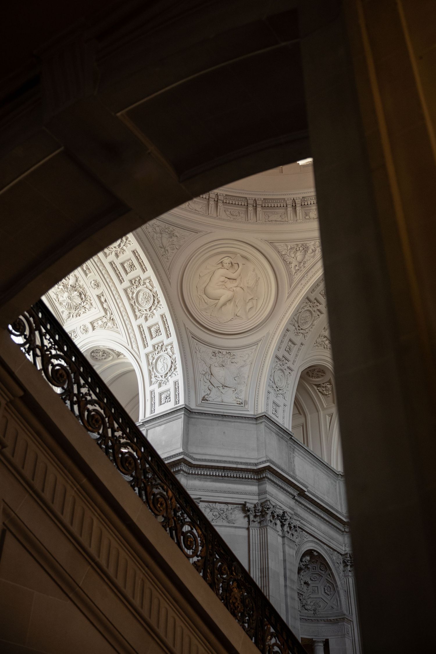 Ornate classical ceiling with intricate plasterwork, medallion relief, and decorative moldings inside San Francisco City Hall.