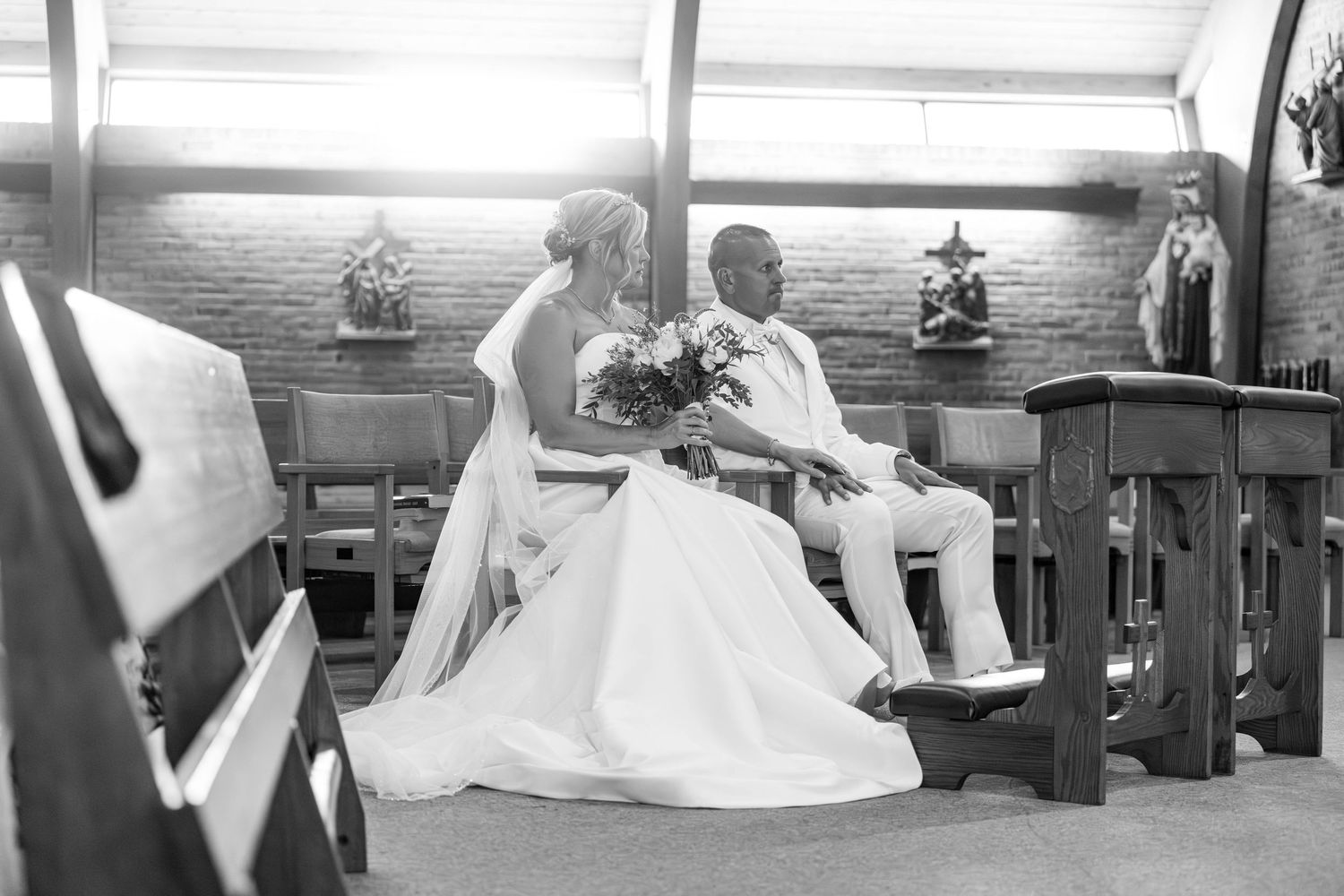 Bride and groom seated together at church altar during wedding ceremony.