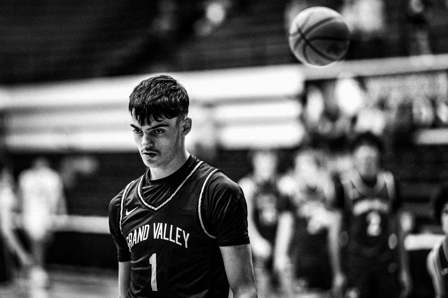 Young basketball player in a Grand Valley jersey standing on the court.