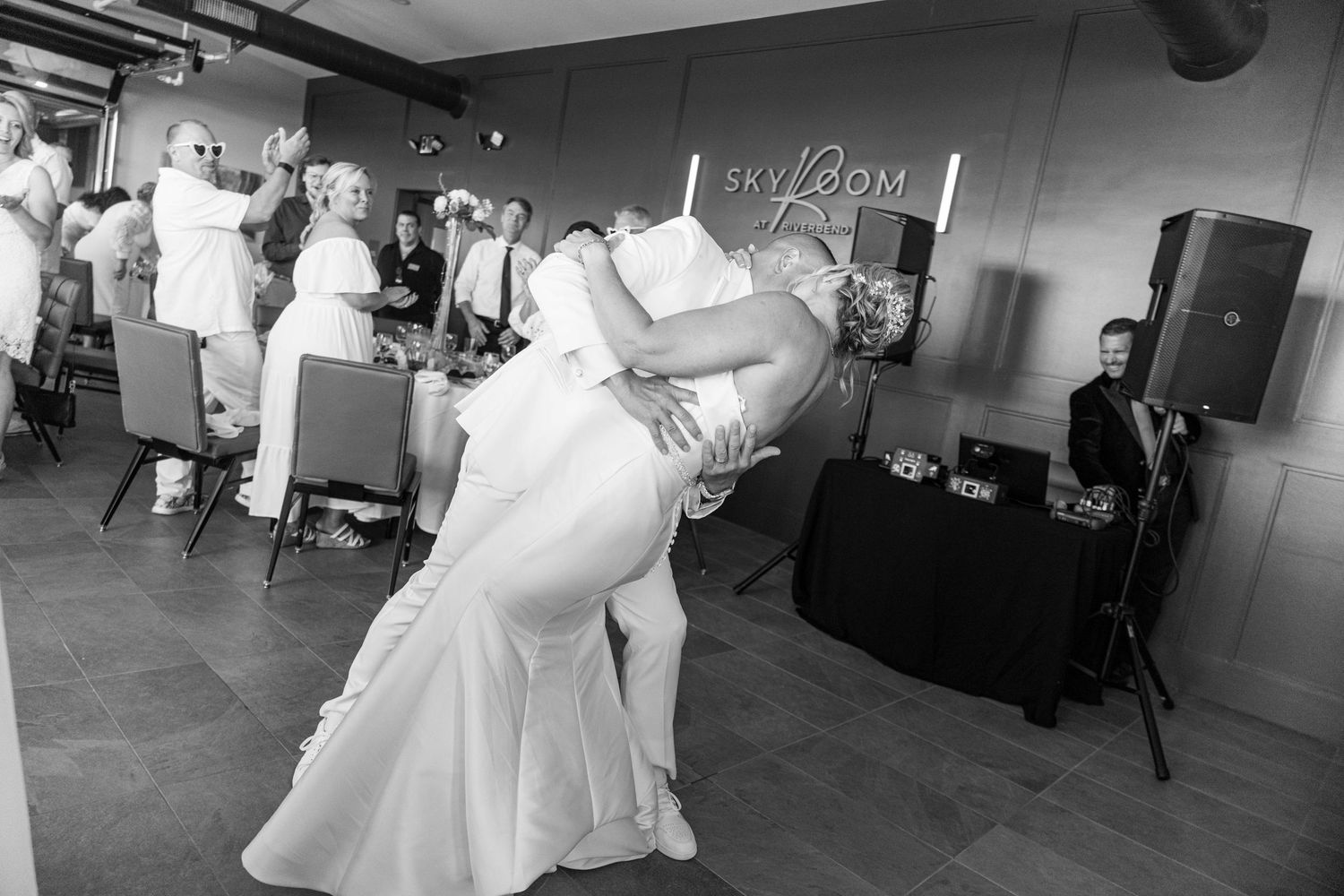 Groom dips bride during their first dance at a wedding reception venue called Sky Room.