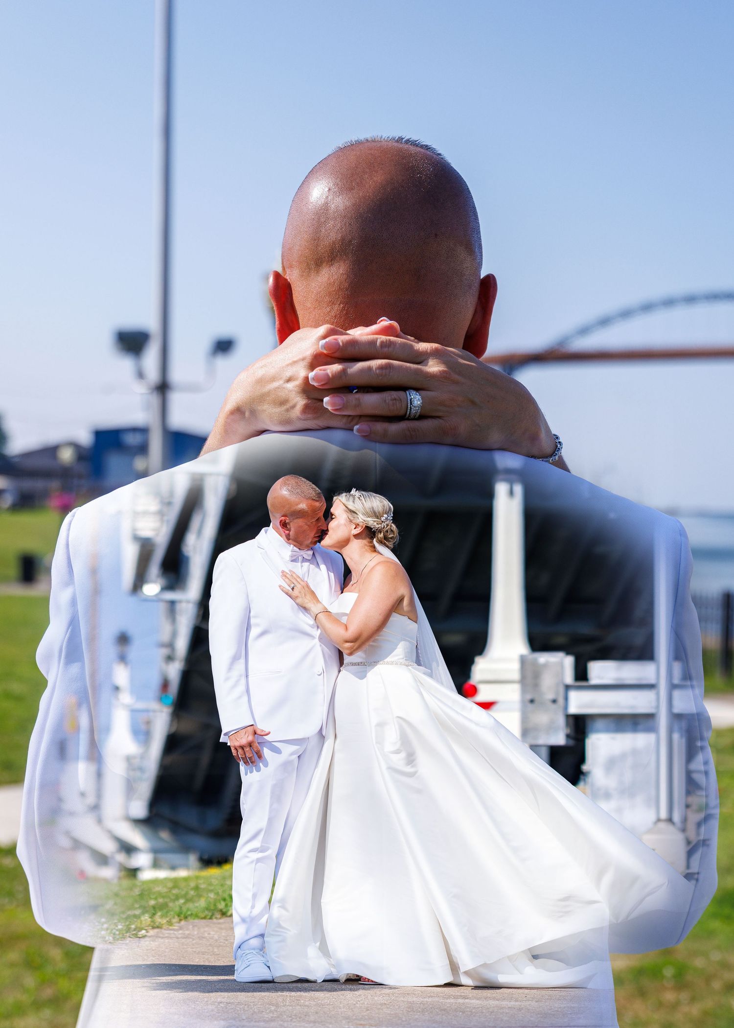 A creative double exposure wedding photo shows a bald groom embracing his bride in a white dress outdoors.