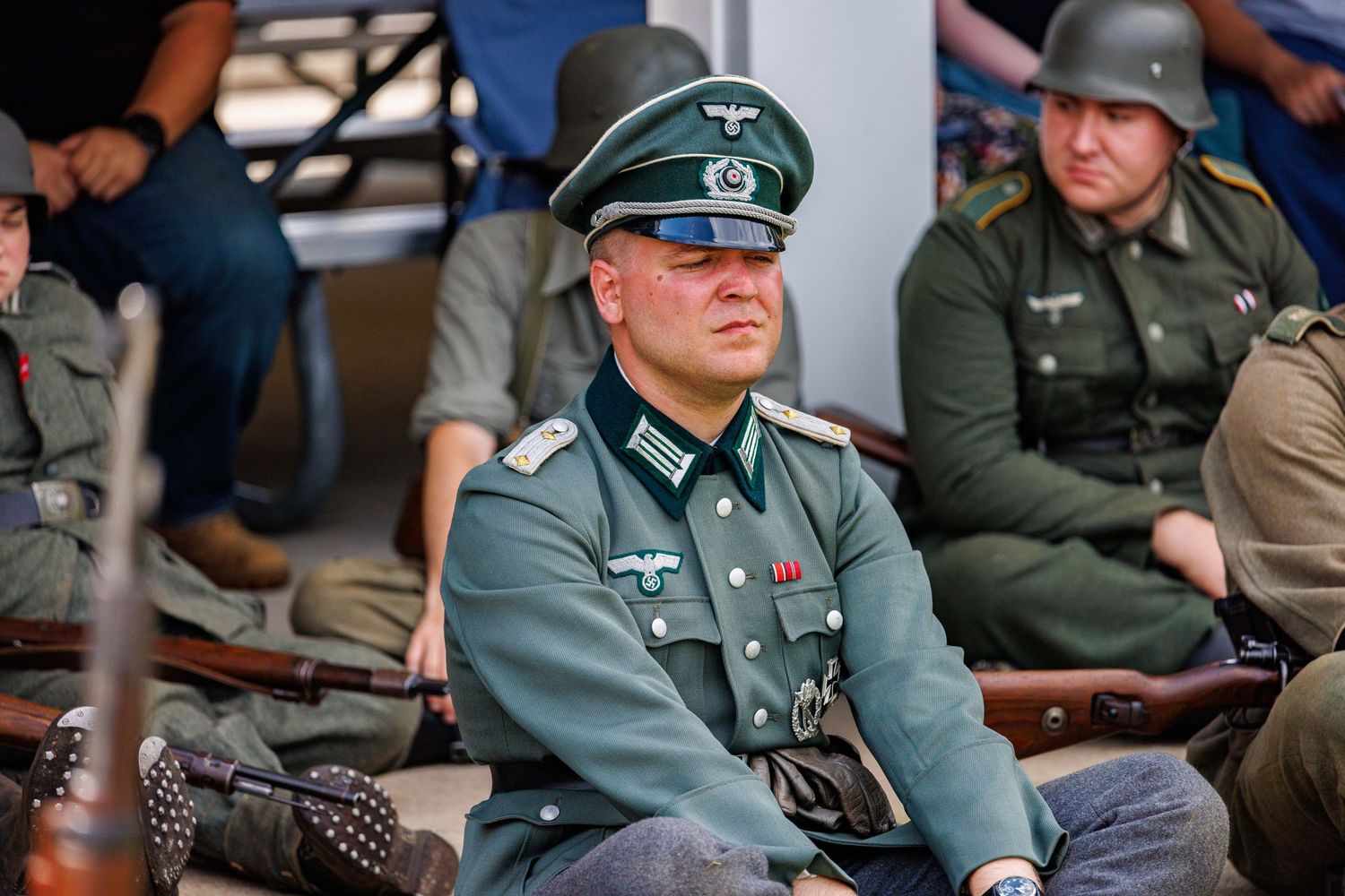Man dressed in WWII German officer uniform at a historical military reenactment event.