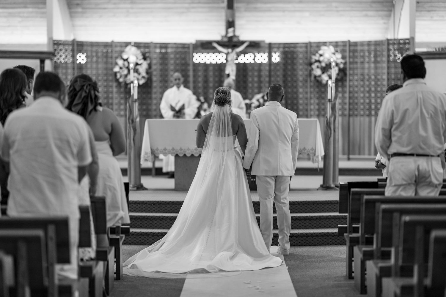 A bride and groom stand at the altar during their church wedding ceremony in this classic black and white photo.