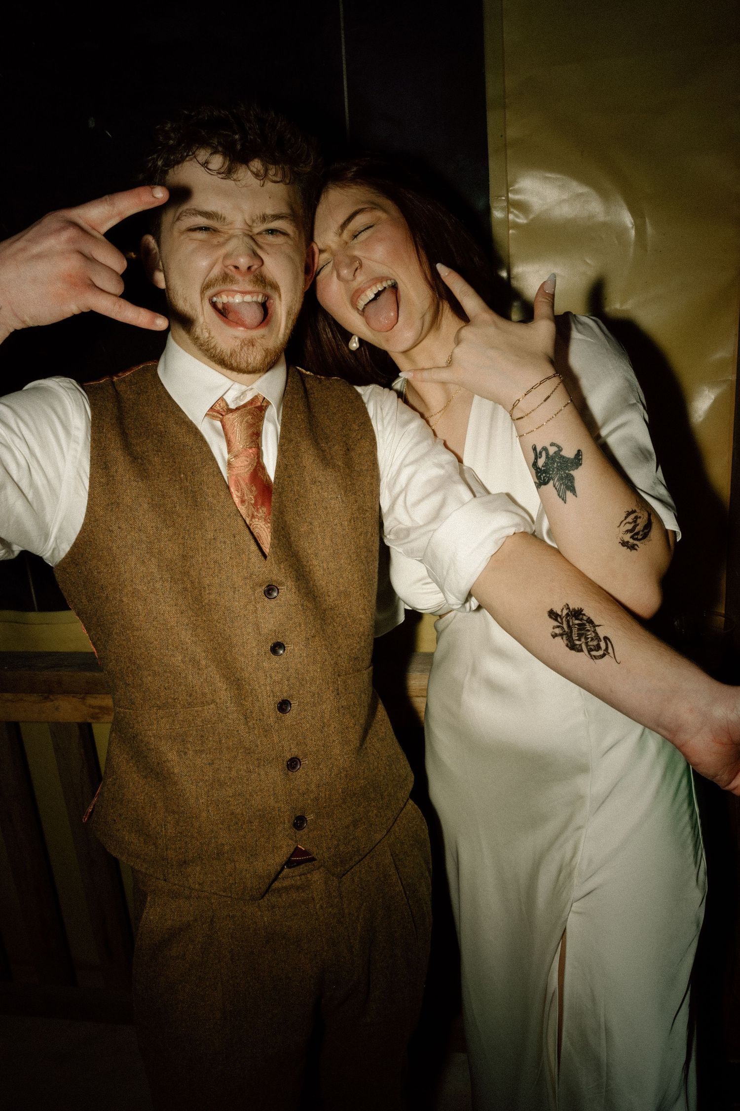 Bride and groom laugh and pose playfully at fun wedding reception celebration.