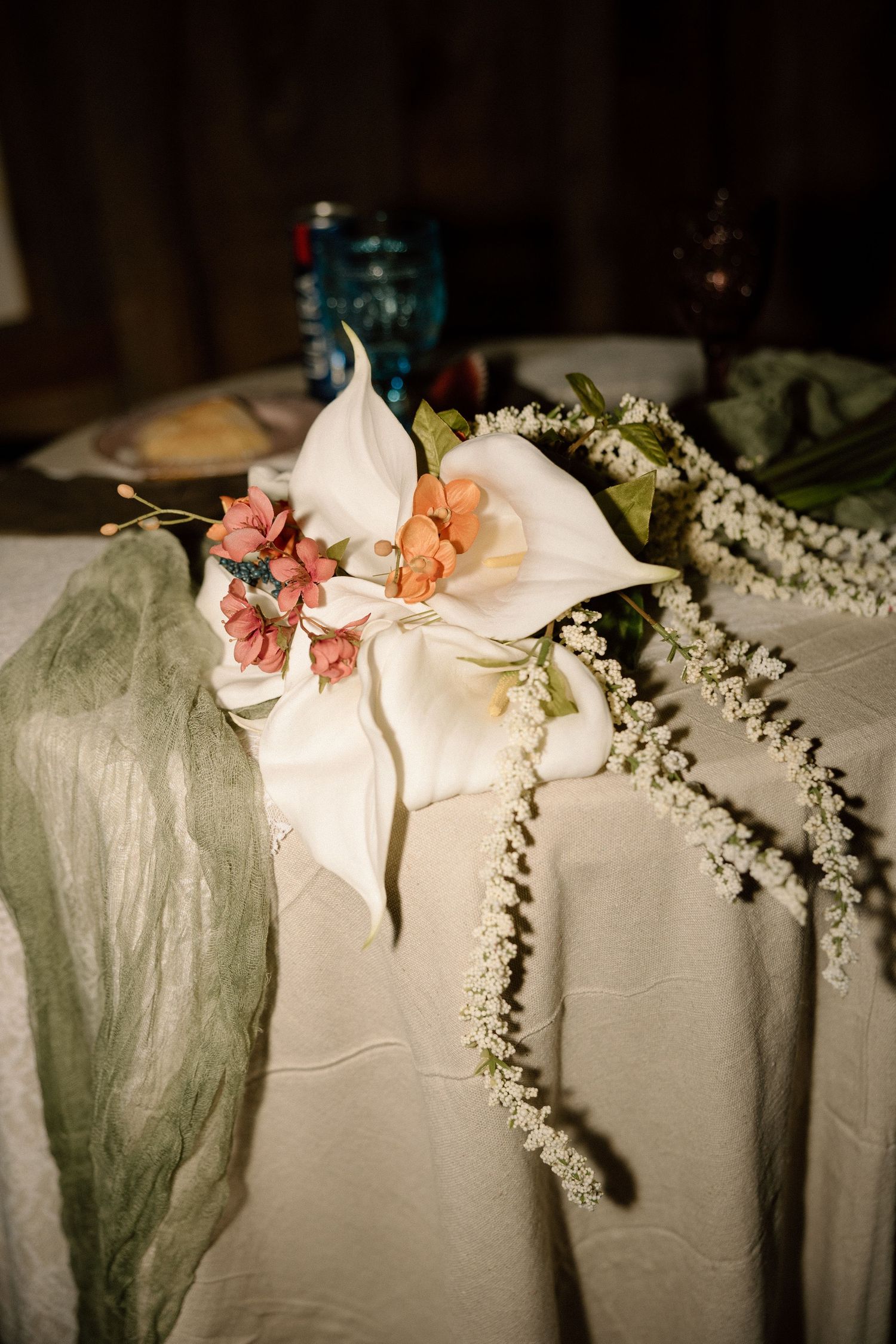 Elegant white calla lily and floral wedding table centerpiece with greenery accents.