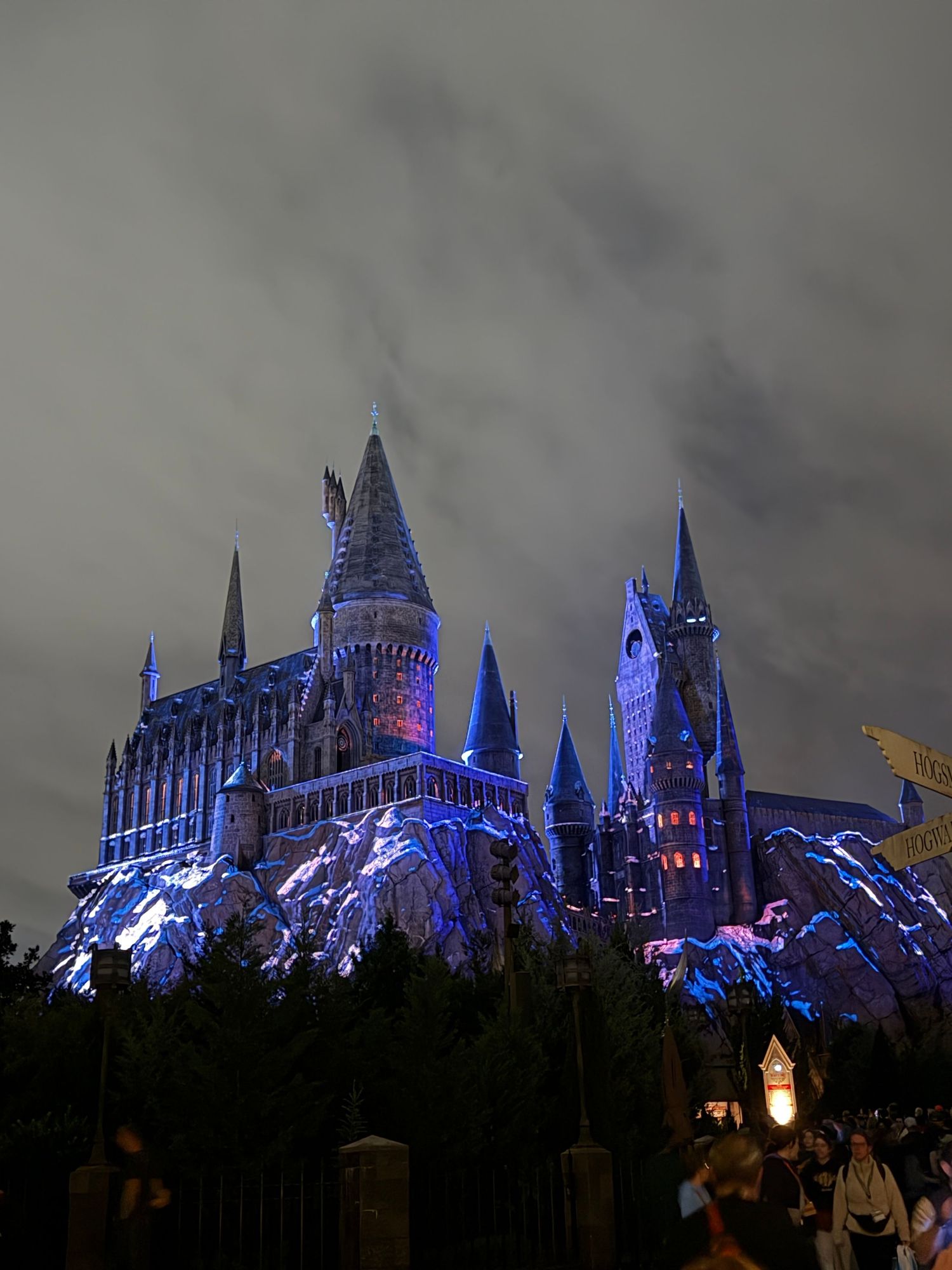 Hogwarts castle illuminated with blue lights at night at Universal Studios theme park.