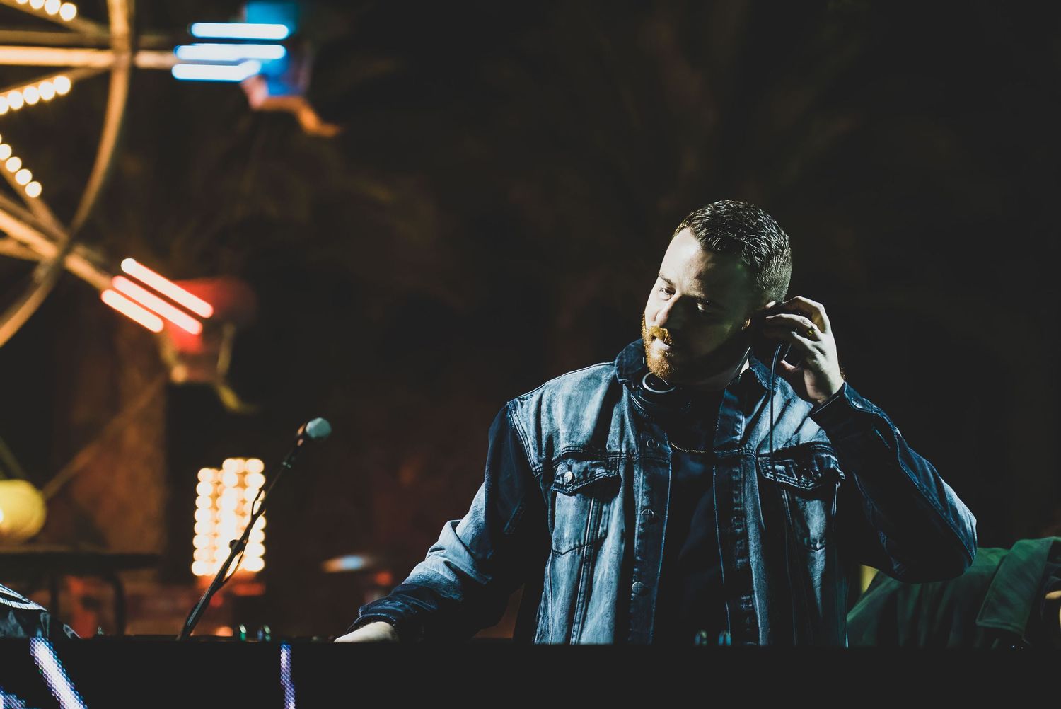 Mountain Productions image of a DJ playing music with a ferris wheel behind him at a corporate event.