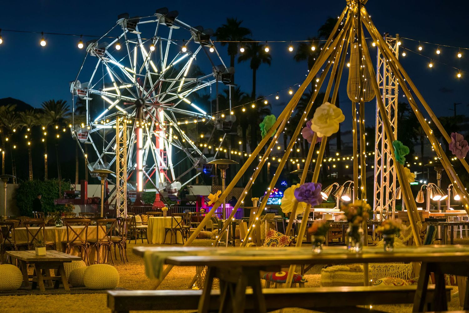 Mountain Productions image of an outdoor venue, at night, with string lights and decor, with a ferris wheel in the background.