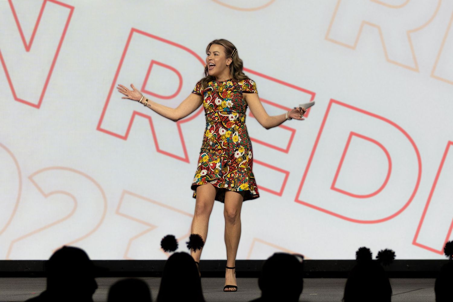 Mountain Productions image of a corporate guest speaker on stage, excited to elevate the crowd in front.