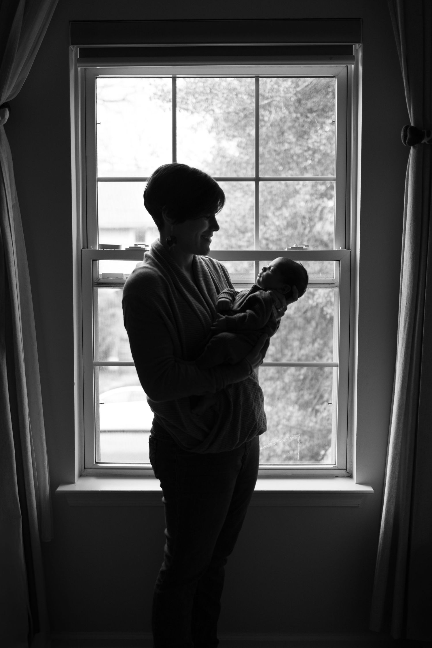 Silhouette of parent holding newborn during lifestyle newborn photo session in Camden County, New Jersey, by Rego Photography