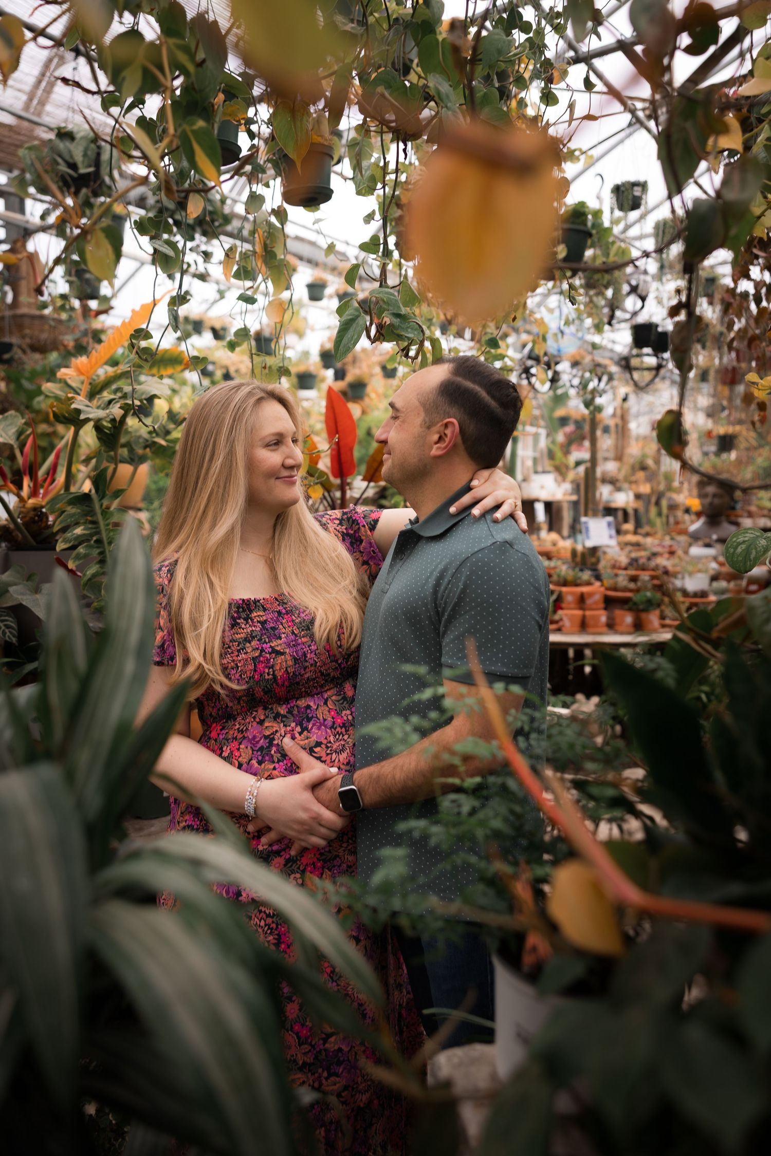 Pregnant couple captured by Rego Photography, newborn and maternity photographer, in a greenhouse setting in Mercer County, New Jersey