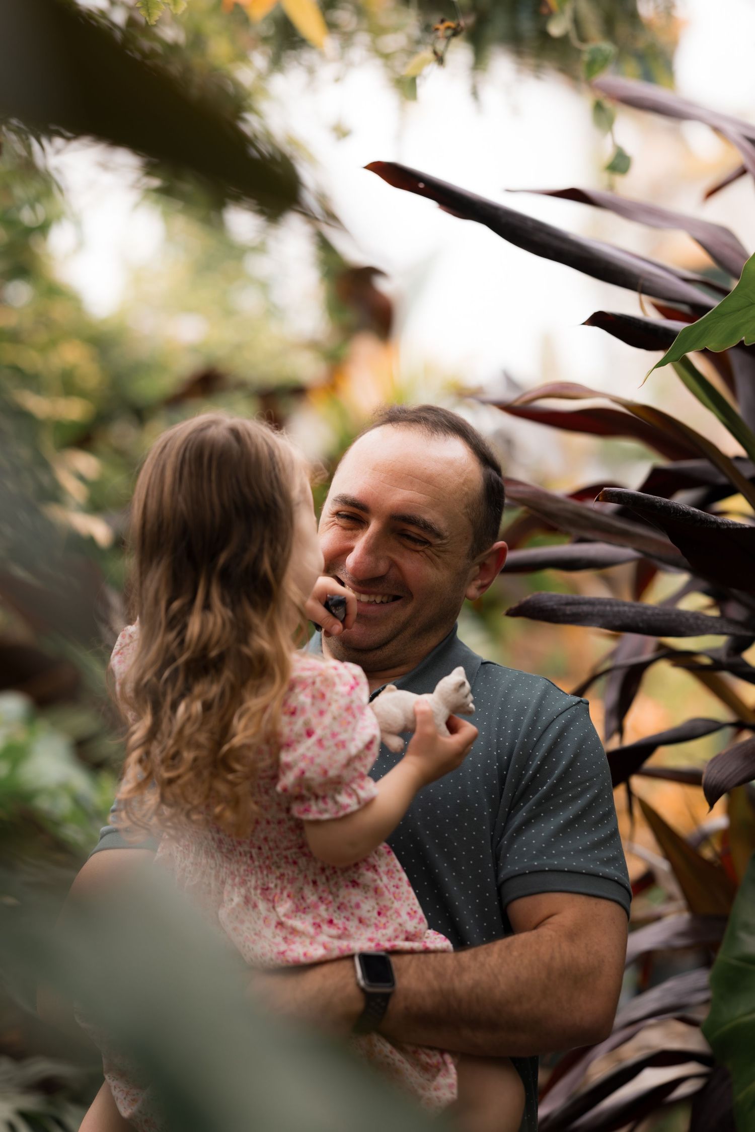Dad and daughter smiling during maternity/family photo session in greenhouse in Mercer County, New Jersey, by Rego Photography
