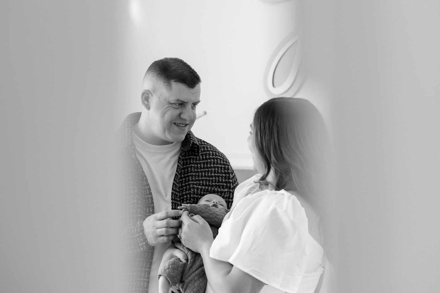 New parents holding newborn baby during lifestyle newborn photo session in Burlington County, New Jersey, by Rego Photography