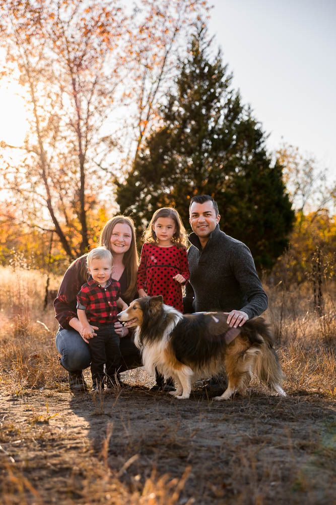 Family with pet dog in field during golden hour during fall family photo session at Boundary Creek Natural Resource Area in Moorestown, NJ