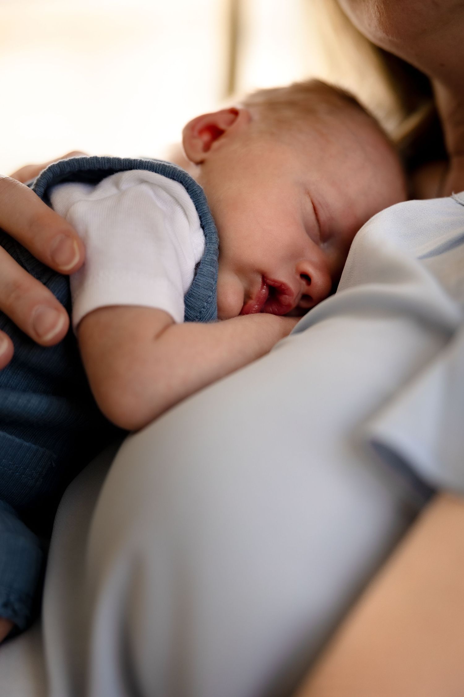 Sleeping baby resting on mother during lifestyle newborn session in Collingswood, New Jersey, by Rego Photography, newborn photographer