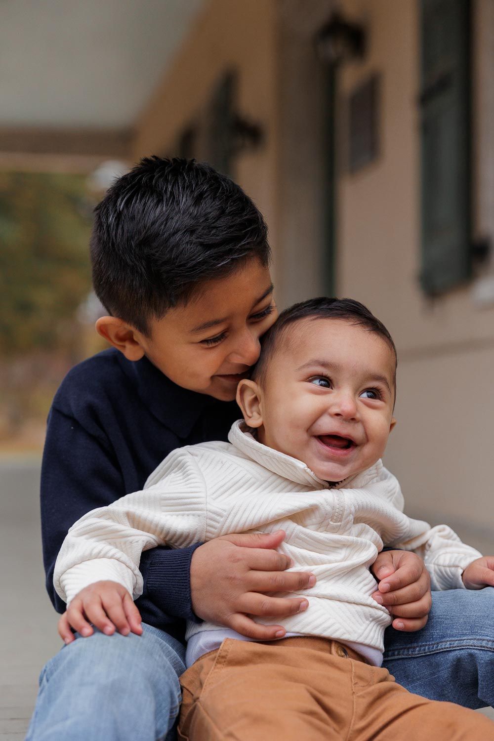 A series of candid photos showing tender moments between a young child in white and a caregiver in blue denim.