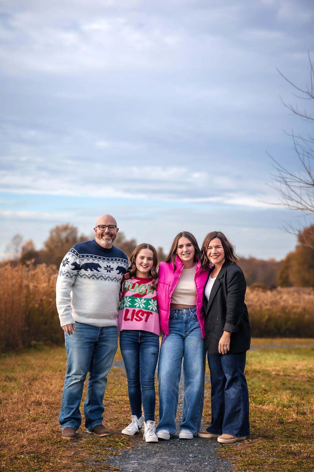 Family photo session alongside field of tall grass at Swedes Run in Moorestown, NJ