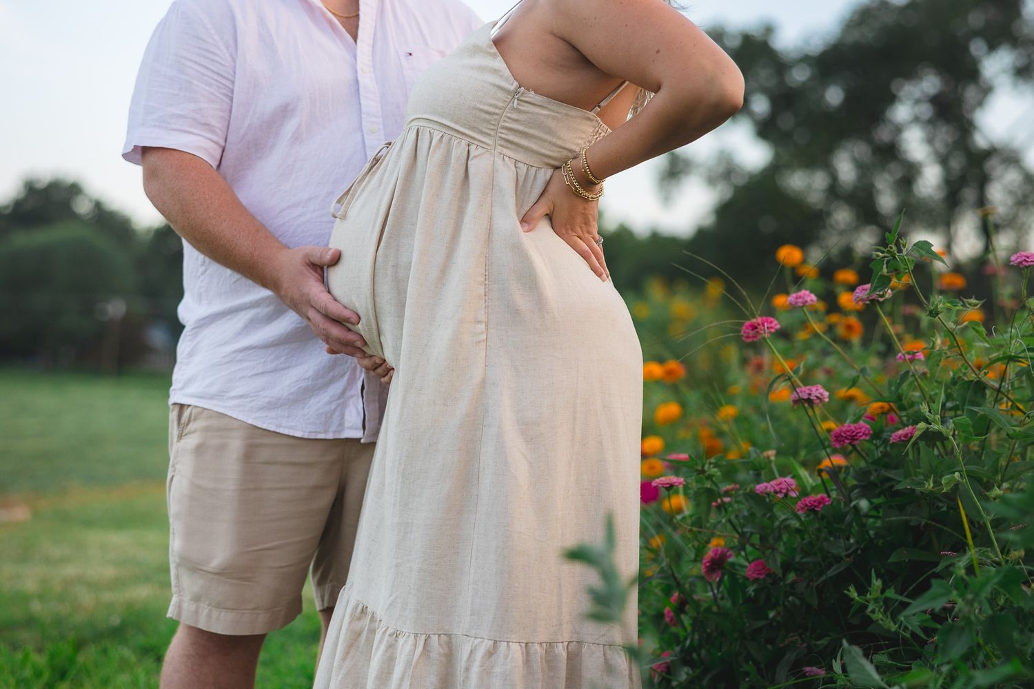 Couple posing outdoors for maternity photo shoot at South Jersey flower field during golden hour maternity session