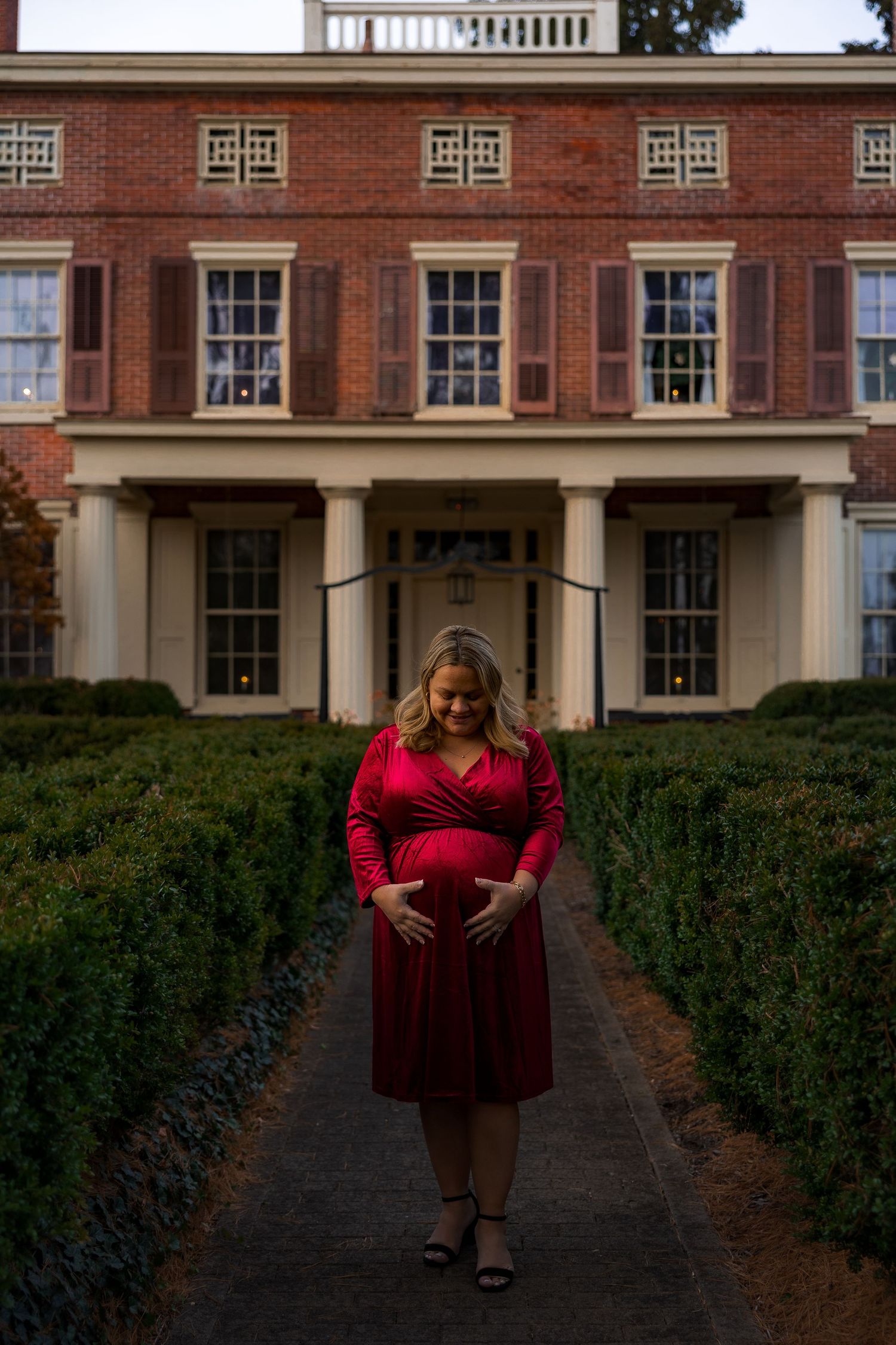 Expectant mother cradling bump during fall maternity session at Smithville Park in Burlington County, New Jersey, by Rego Photography