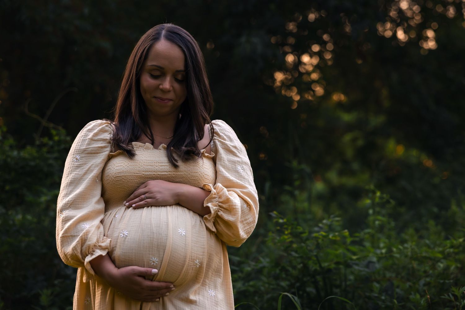 Expectant mother cradling her bump during maternity session at Palmyra Nature Cove in Burlington County, New Jersey by Rego Photography