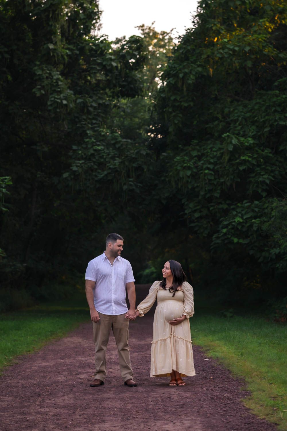 Couple holding hands during golden hour maternity session at Palmyra Nature Cove in Burlington County, NJ