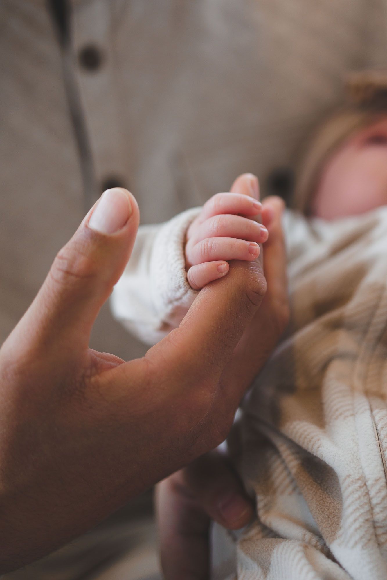 Newborn holding dad's finger during lifestyle newborn session in Burlington County, New Jersey, by Rego Photography, newborn photographer