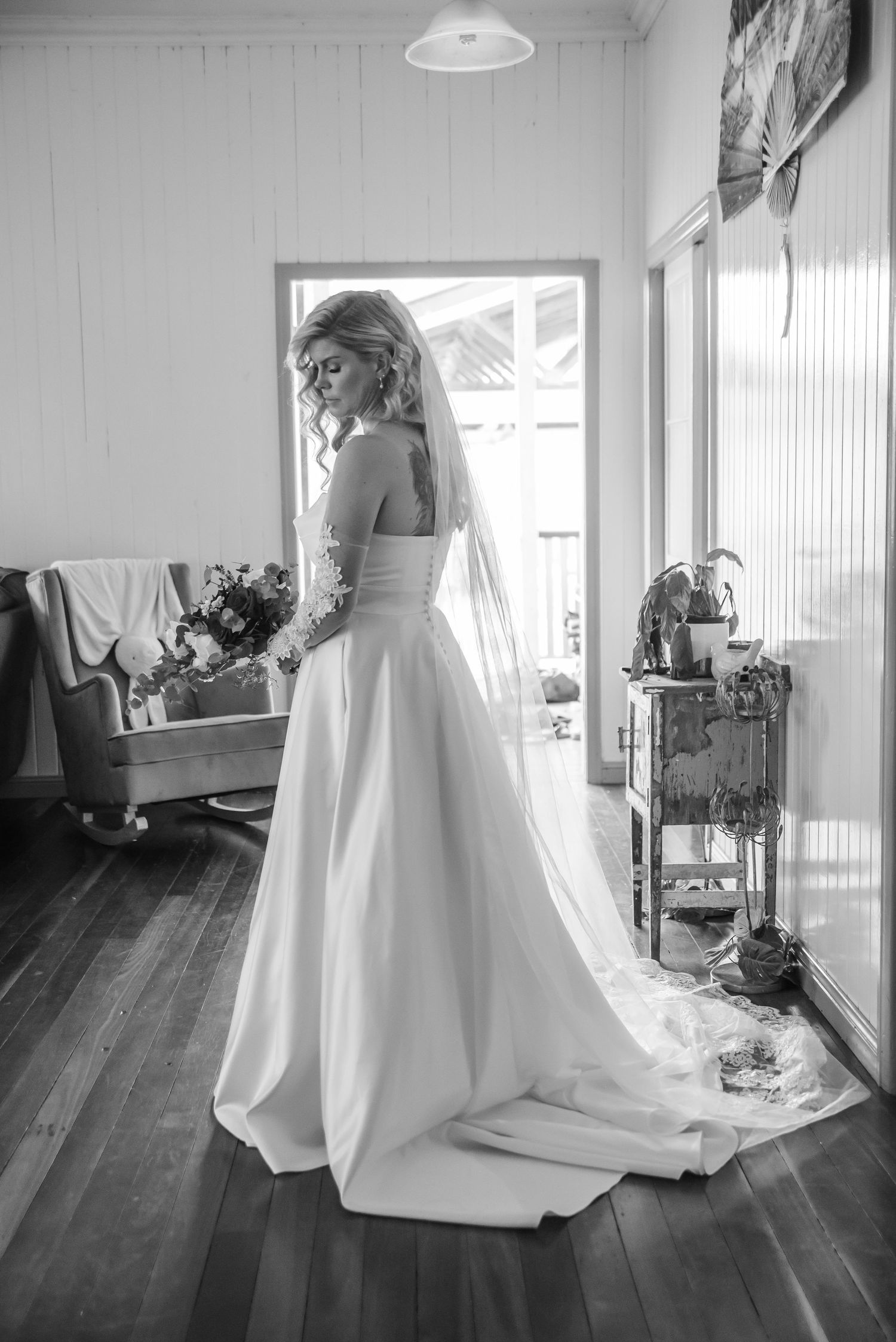 A wedding dress with flowing train photographed from different angles in a bright sunlit room.