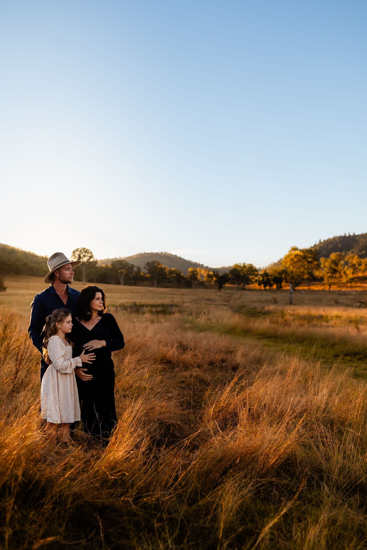 Family silhouettes against stunning mountain landscape at golden hour.