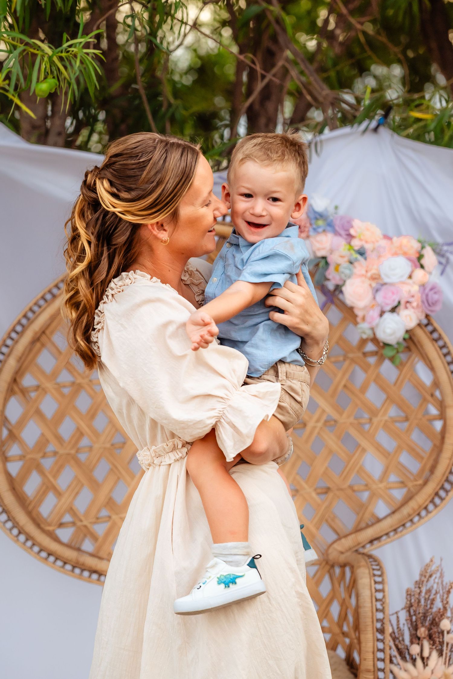 A joyful moment captured outdoors with soft floral decorations and lattice backdrop.