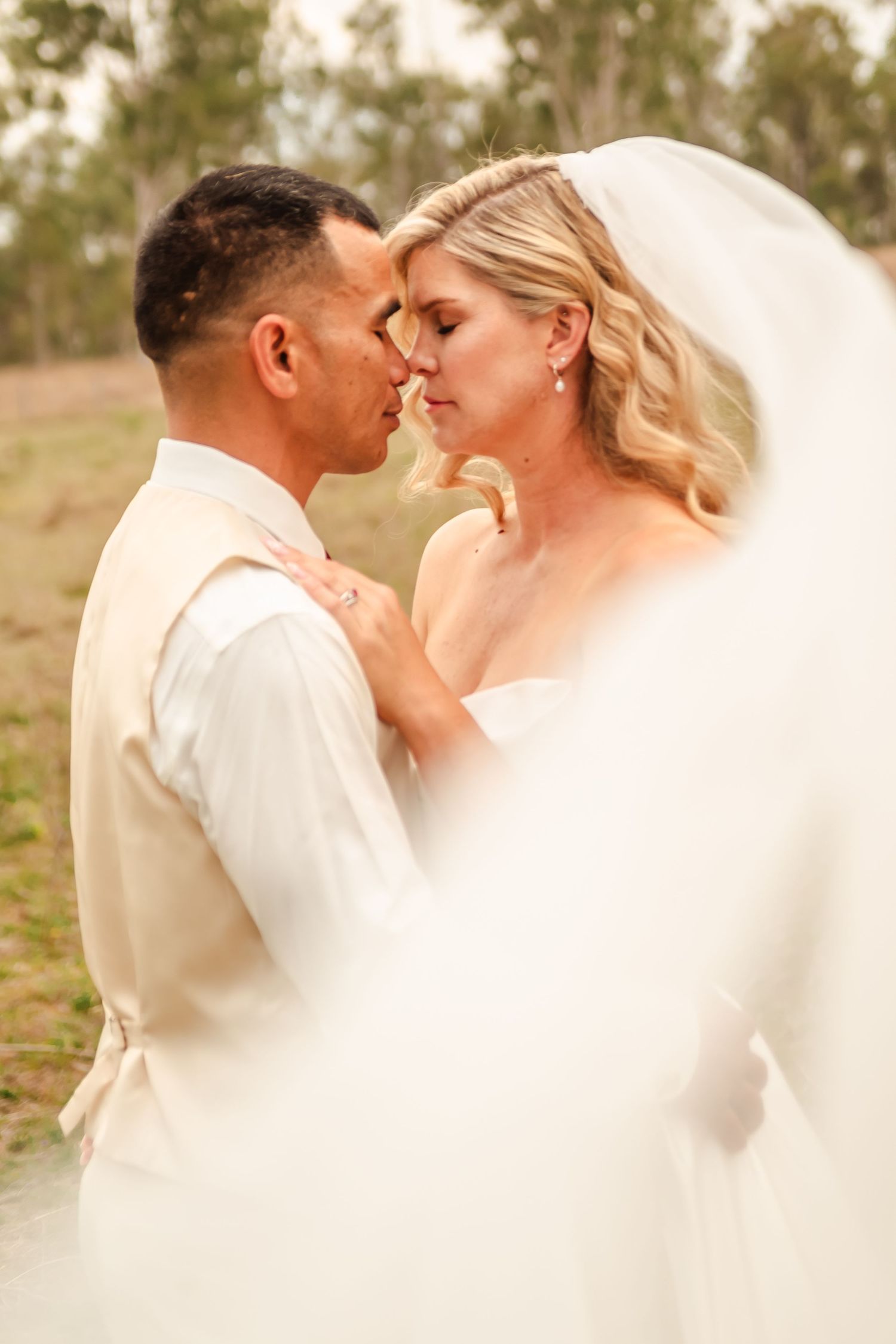 A romantic series of wedding photos showing tender moments between a couple in white attire outdoors.