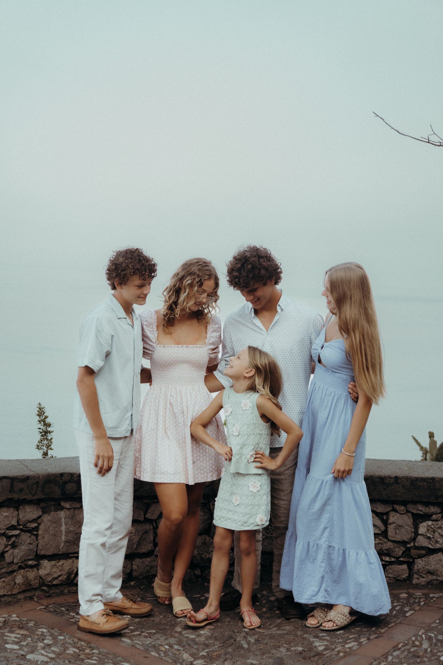 Family cuddling under the golden Sicilian light, warm and emotional portrait