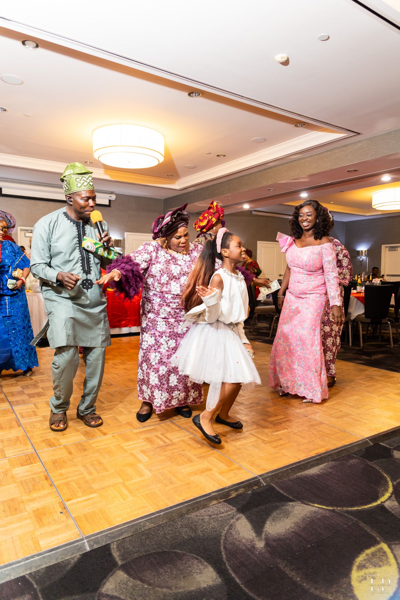 People dancing together on a parquet floor at a cultural celebration.