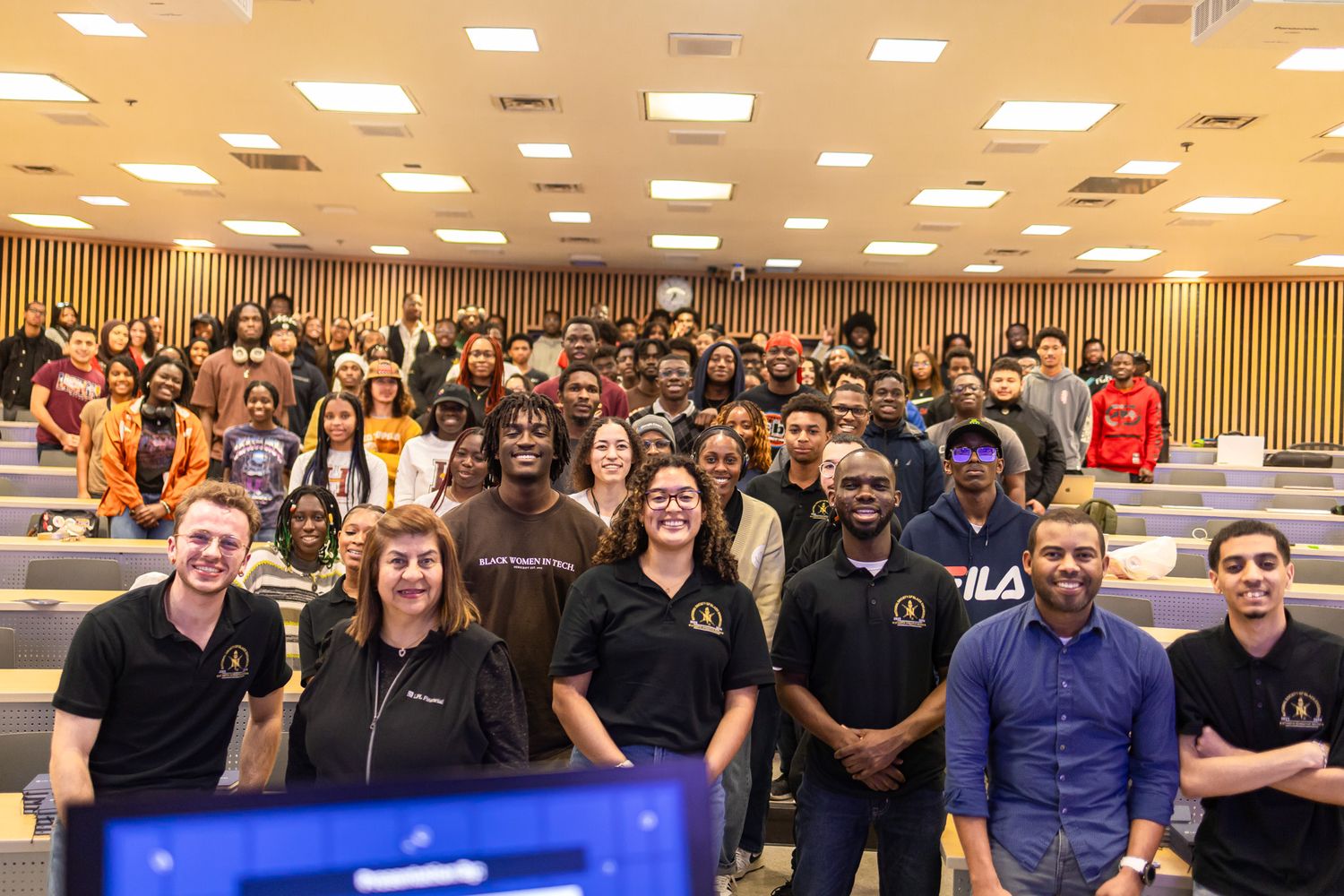 Wide shot of a crowded lecture hall with students attending a presentation or seminar.