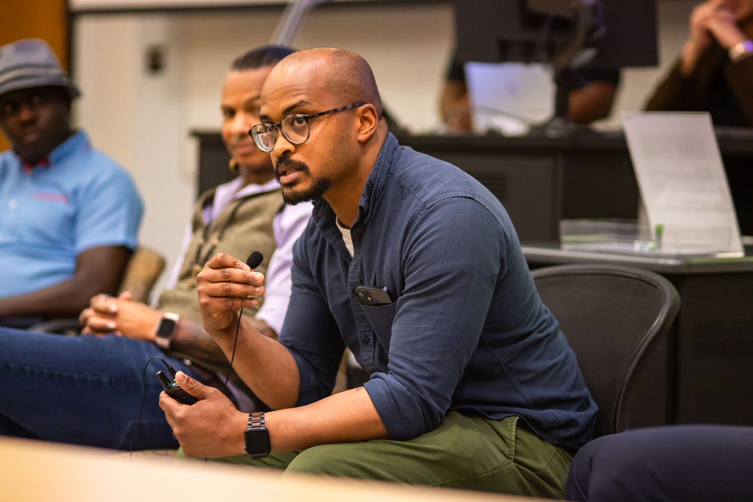 Attendees engage with mobile devices during a conference session.