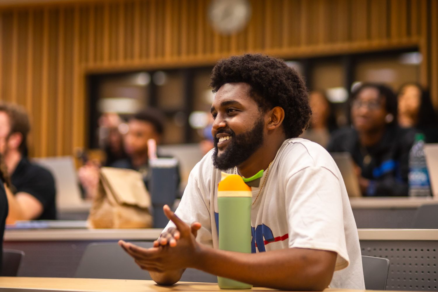 Attendees sit in rows during an educational presentation in a modern lecture hall.
