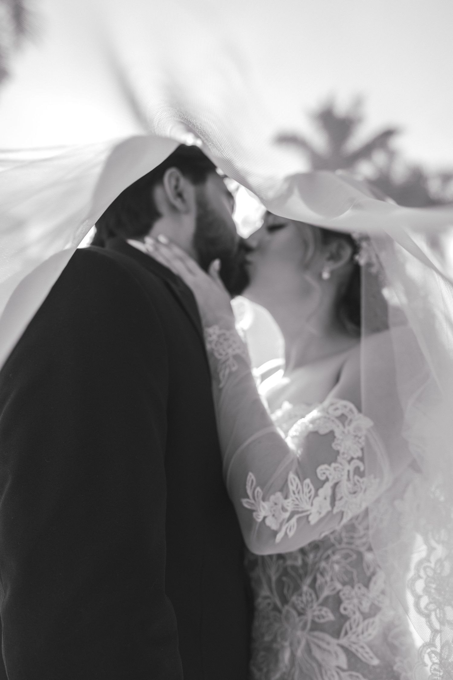 Ethereal black and white wedding portraits capturing romantic moments through delicate lace details.