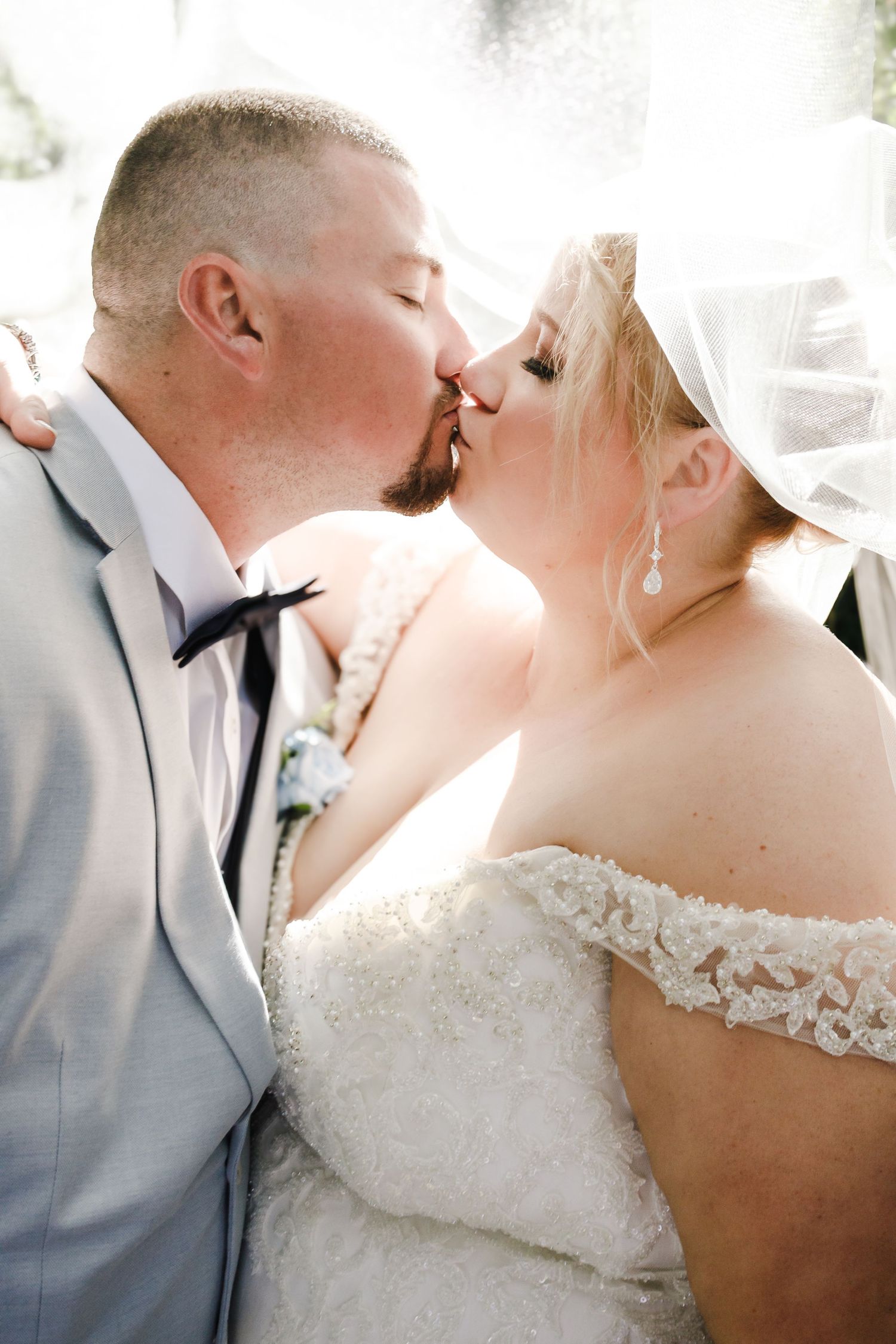 An intimate wedding portrait showing a romantic moment between newlyweds in formal attire.