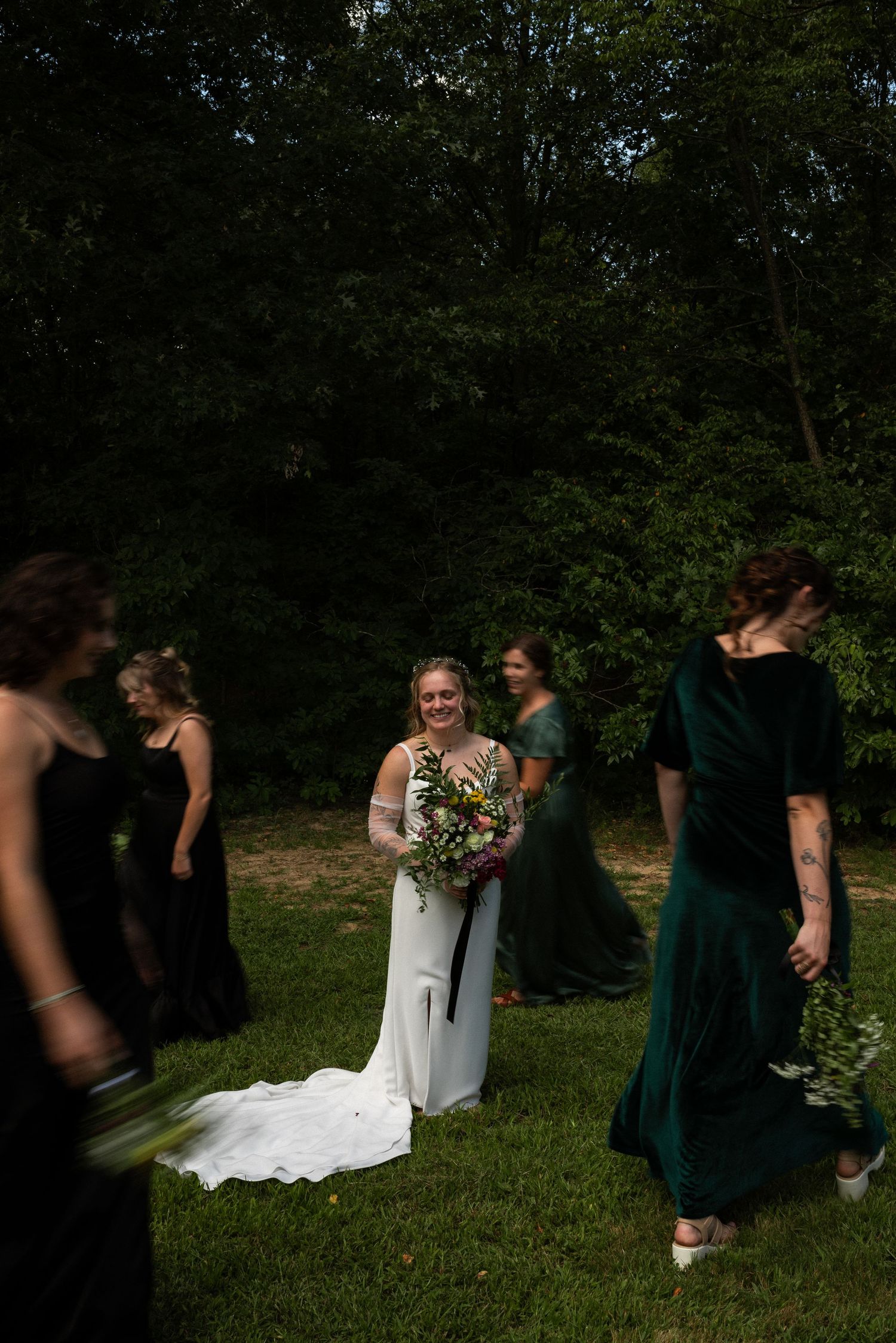 bride standing still as bridesmaid walk around her
