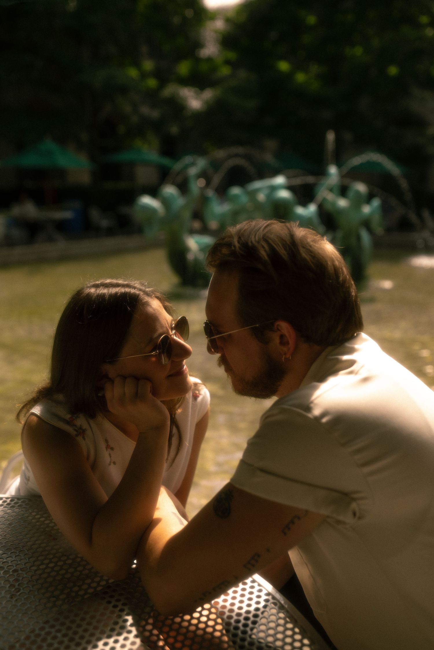 Engaged couple in Chicago looking at each other while sitting at a table outside