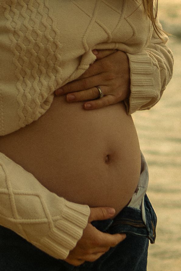 Close up of pregnant belly on the beach.