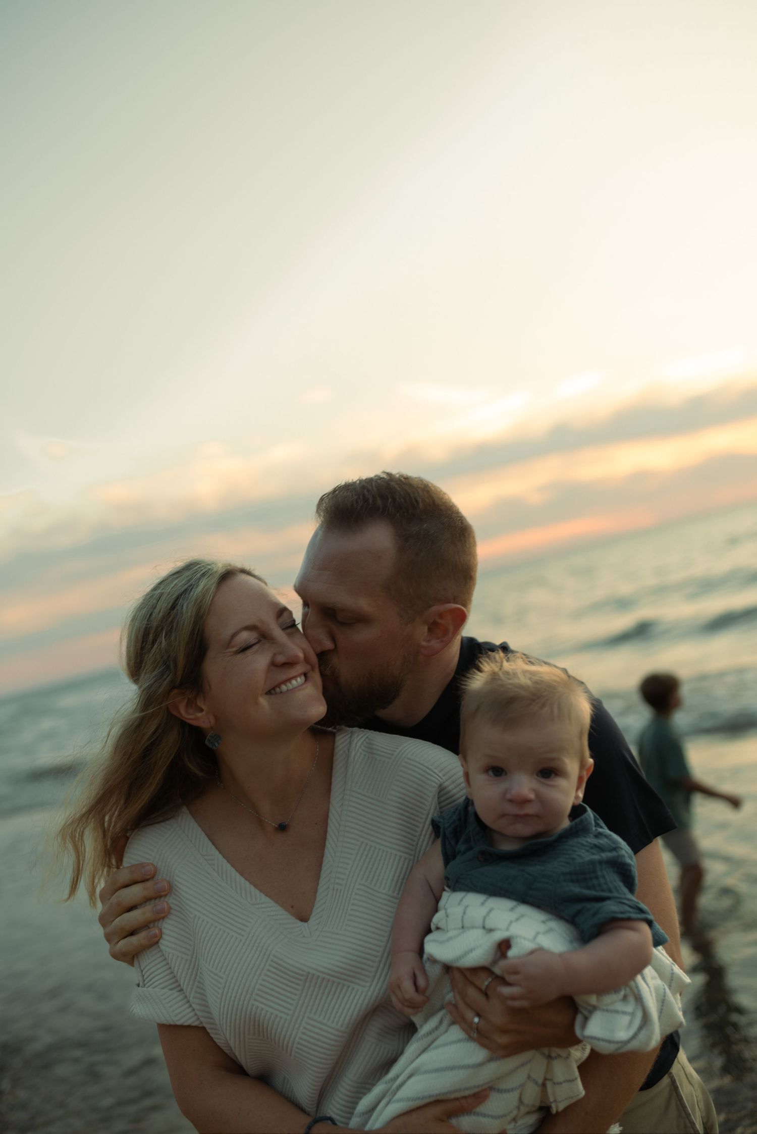 husband, wife, and son hugging