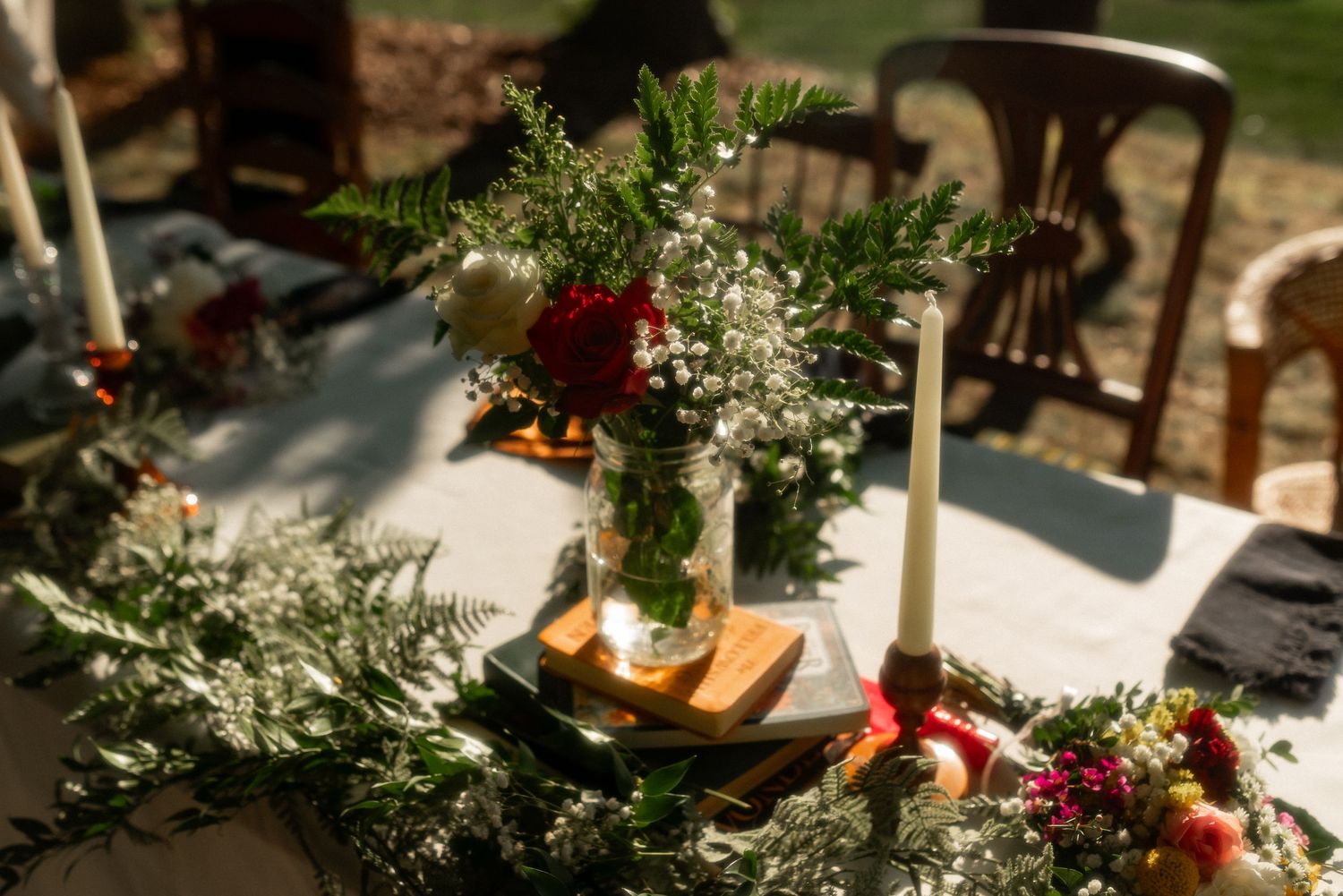 wedding party table details with flowers, candles, and books