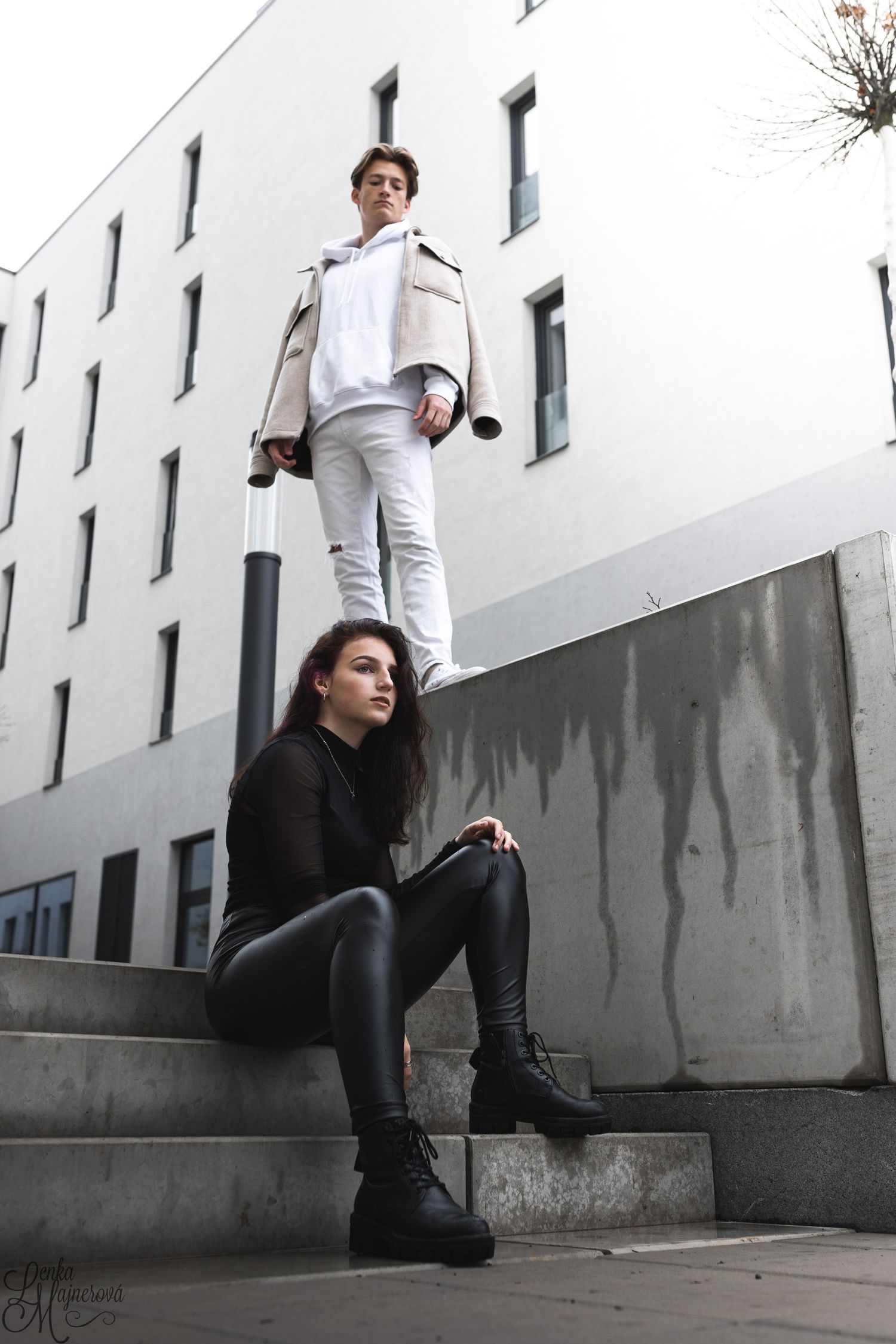 Urban fashion shoot on concrete steps against white modern building.