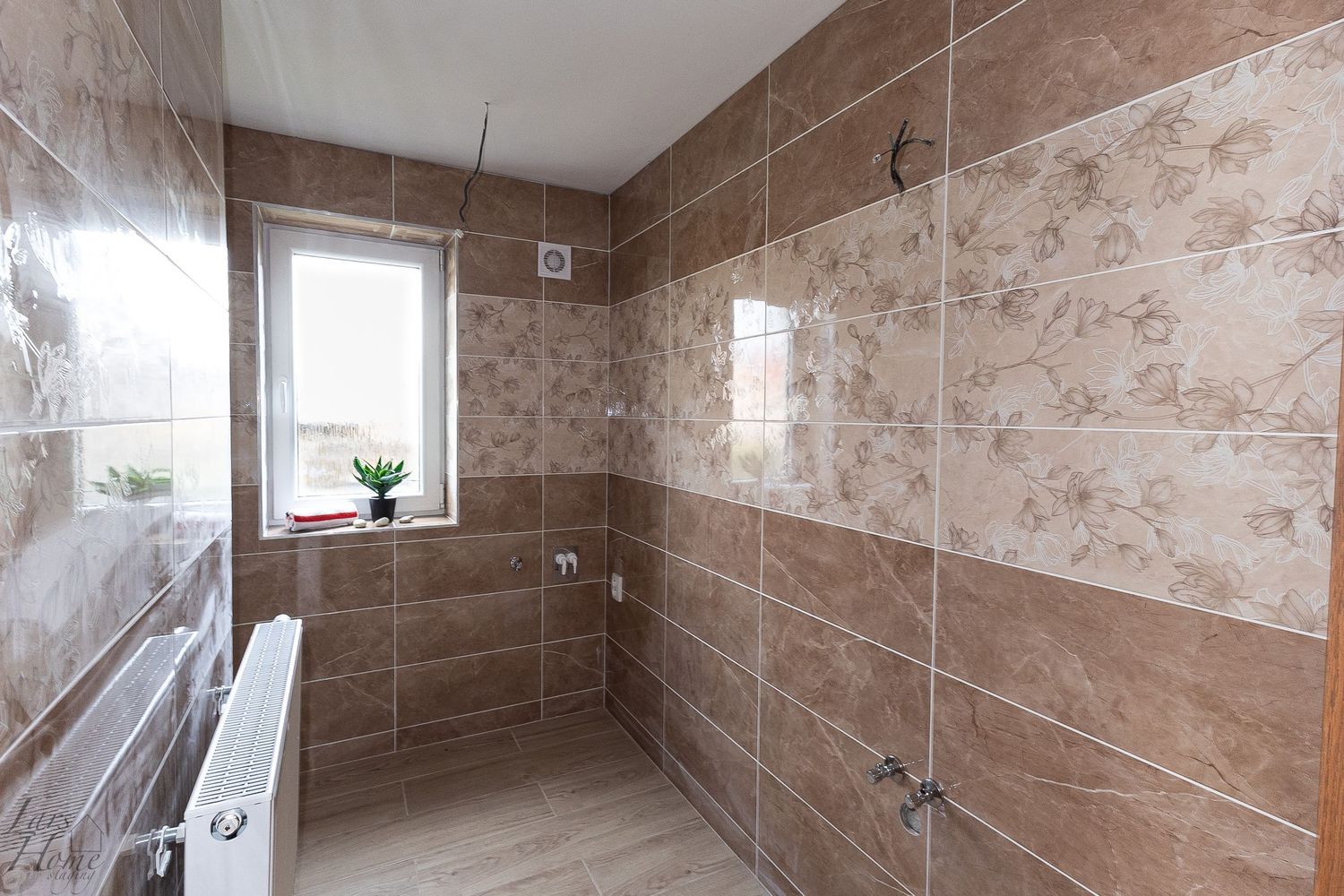 Modern bathroom interior with brown marble tiles covering walls and floor, featuring sleek fixtures and glass accents.