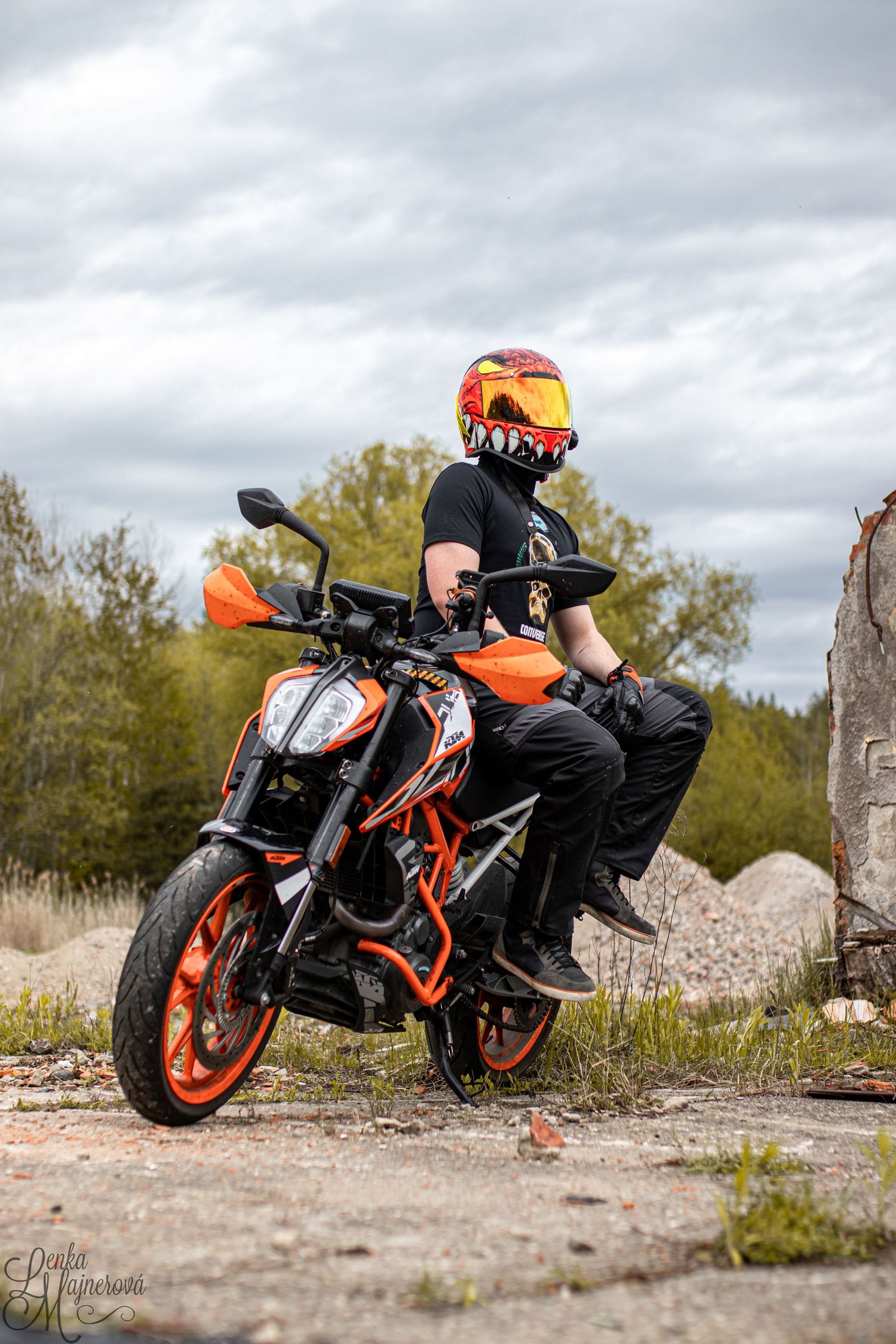 KTM Duke motorcycle being ridden on rough terrain near concrete ruins.