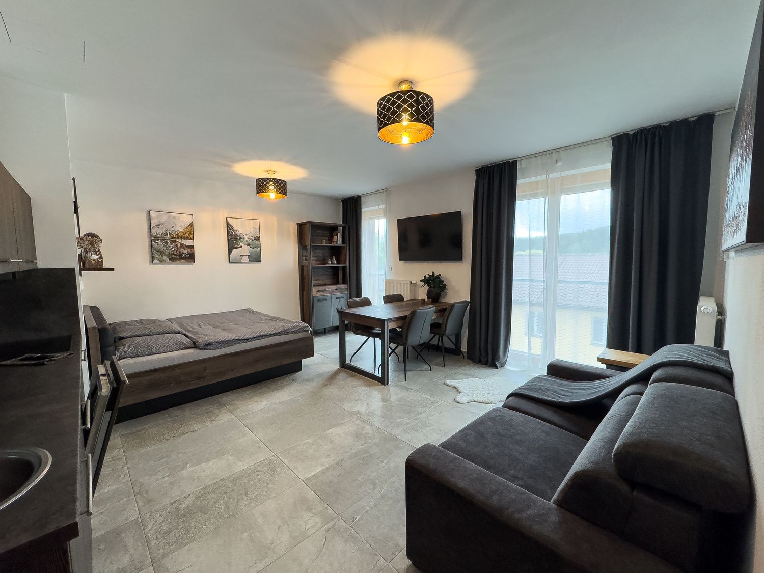 Modern apartment interior showcasing multiple rooms with dark curtains, sleek furnishings, and contemporary lighting fixtures.