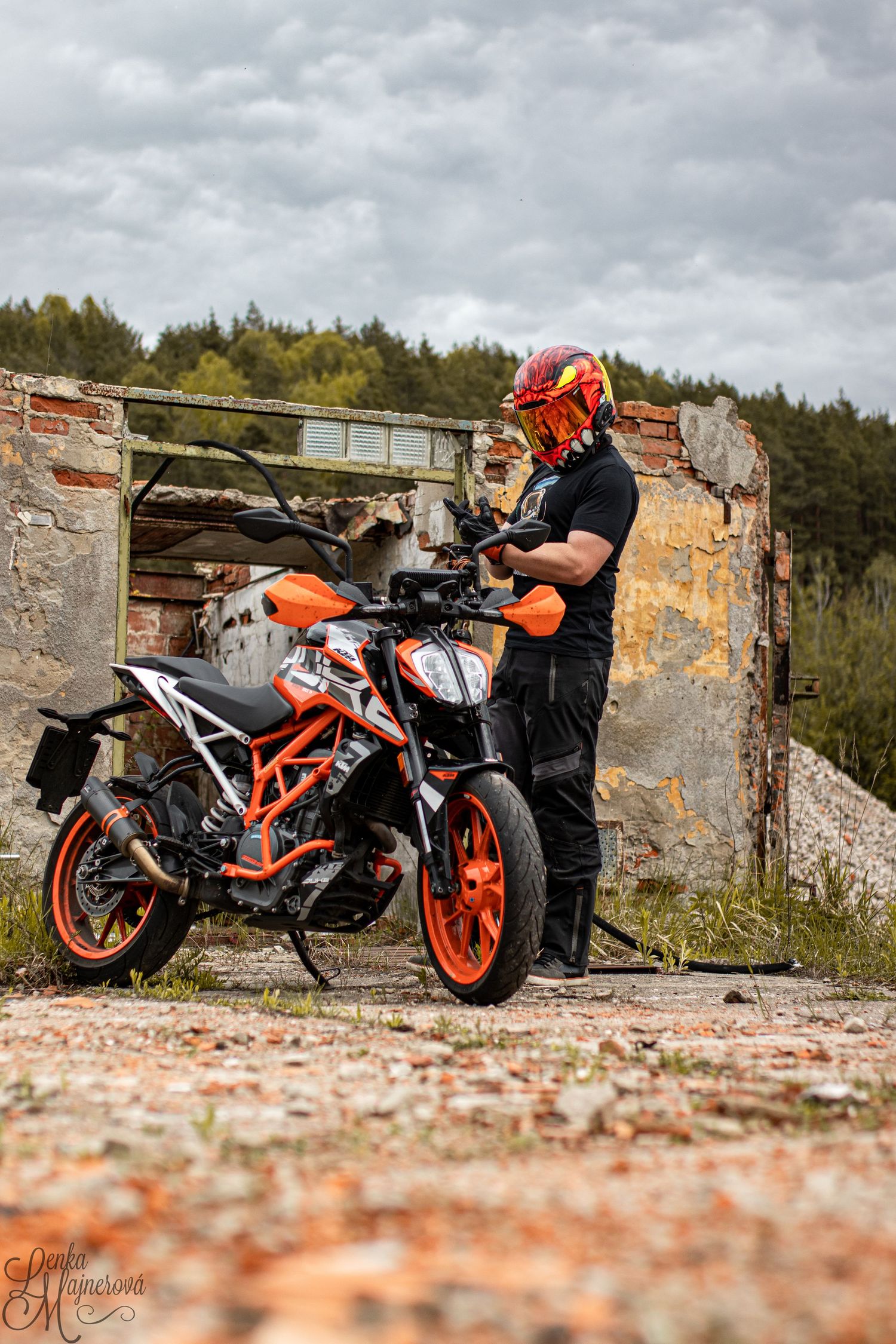 KTM Duke motorcycle displayed near abandoned brick ruins under cloudy sky.
