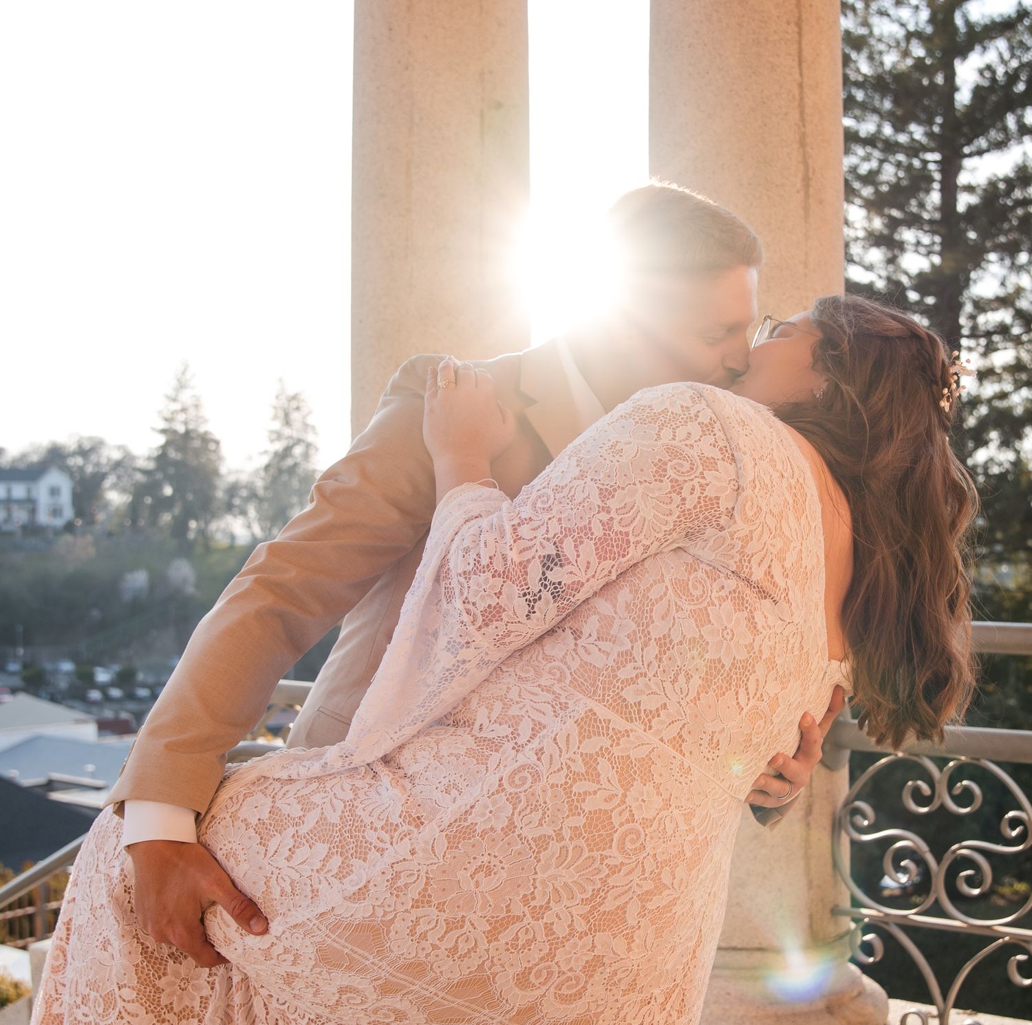 Romantic outdoor wedding photos captured during golden hour with sunlit columns.