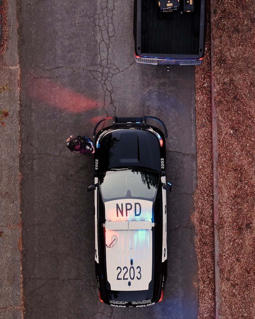 Aerial view of police vehicles parked in formation with visible unit numbers.